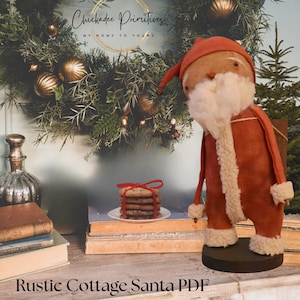 May include: A fabric Santa Claus figurine with a red hat and coat, white faux fur trim, and a white beard, standing on a round base. Beside it are stacked cookies tied with a red ribbon, old books, and a glass bottle, with a wreath background.