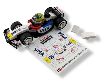 May include: A miniature race car toy with a driver in a helmet. The car is white, black, and blue with "VISA", "HUGO", and "Red Bull Cash App" branding. Includes a sheet of stickers and two white blocks.