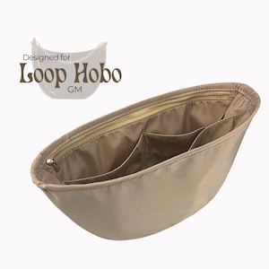 Puede incluir: Organizador de bolso de tela beige con varios bolsillos y una cremallera dorada. Diseñado para Loop Hobo GM.