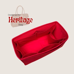 May include: A vibrant red bag organiser with several pockets. The text "Designed for Heritage Bag" is displayed in red. The organiser is designed to fit inside a handbag.