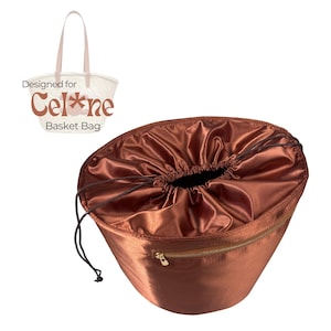 May include: A brown satin basket bag with a drawstring closure and a gold zipper. The bag is designed for a Celine basket bag. The bag has a drawstring closure and a gold zipper.