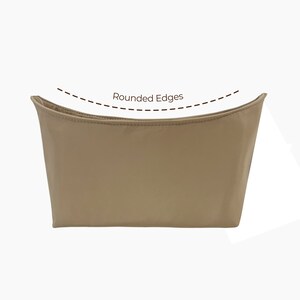 May include: A beige makeup bag with rounded edges. The bag is made of a soft, smooth fabric.
