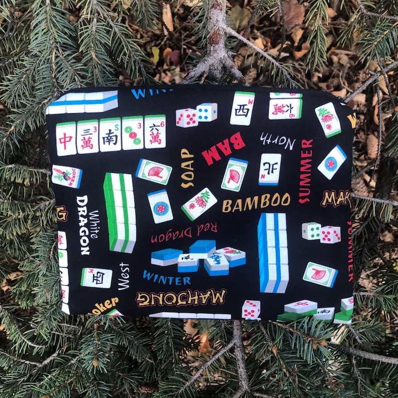 May include: Black Mahjong-themed fabric with various tiles, dice, and text. The design includes the words "White Dragon," "Bamboo," and "Winter." The fabric is covered in colorful Mahjong tiles and dice.