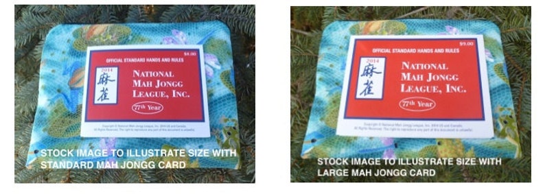 May include: Two images of Mah Jongg cards on a patterned fabric. The cards are red and white, with the text "National Mah Jongg League, Inc." and "77th Year." One image shows a standard-sized card, the other a larger card.