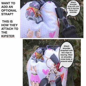 May include: A white drawstring bag with a cat print design. The bag has two black straps that can be attached to a keyring or worn as a shoulder strap. The text "Want to add an optional strap? This is how they attach to the Kipster" is visible in the image.