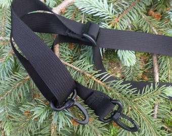 May include: Black adjustable strap with two black metal clips. The strap is made of a woven nylon material.