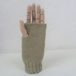 May include: A pair of beige fingerless knitted gloves with a ribbed cuff.