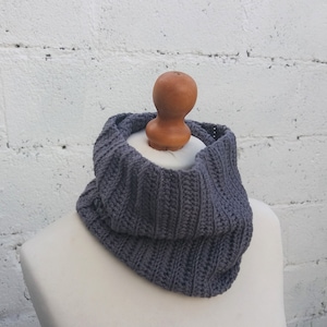 May include: A gray crocheted cowl neck scarf on a white mannequin.