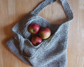 May include: A gray crocheted tote bag with four red apples inside.