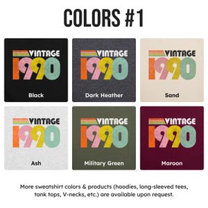 May include: Six color swatches showing different color options for a vintage 1990 t-shirt. The colors are black, dark heather, sand, ash, military green, and maroon.