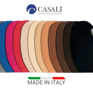 Può includere: Una varietà di tacchi in pelle di diversi colori, tra cui grigio, blu, rosa, rosso, beige, marrone chiaro, marrone scuro e nero. I tacchi sono disposti a semicerchio e sono etichettati con "Casali Italian Shoe Accessories" e "Made in Italy".