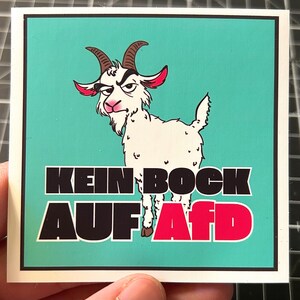 May include: A square sticker with a teal background features a cartoon goat with a stern expression. The goat is white with brown horns and red accents. Bold black text reads "KEIN BOCK" above "AUF AFD" in red, creating a political statement.