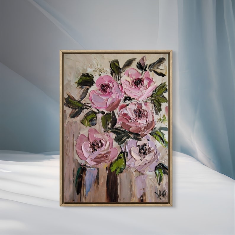 Puede incluir: Una pintura enmarcada de un ramo de flores rosas y blancas con hojas verdes sobre un fondo beige.