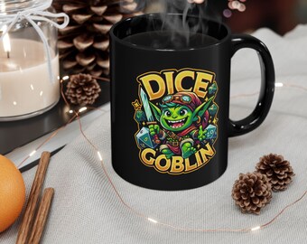 May include: Black ceramic mug with a green goblin character holding a sword and dice. The mug has the text "Dice Goblin" printed on it.