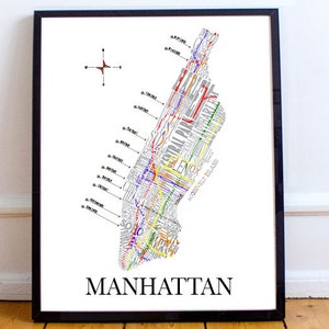 May include: A black framed print of a map of Manhattan, New York City. The map is made up of the names of streets and neighborhoods in the city, arranged in a way that forms the shape of the island. The map is in black, white, red, blue, yellow, and green.