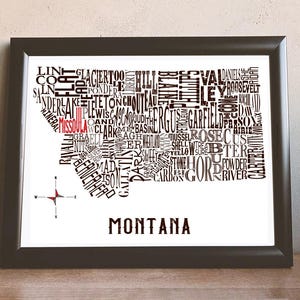 May include: A black and white typography art print of the state of Montana. The state's name is written in large letters at the bottom of the print. The state's outline is formed by the names of cities and towns within the state. The city of Missoula is highlighted in red.