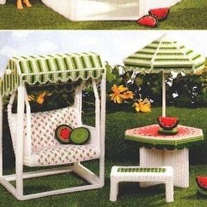 May include: A white plastic dollhouse gazebo with a green roof and a heart-shaped finial. The gazebo has a white picket fence and a bench inside. There is a white plastic dollhouse swing set with a green striped canopy. There is a white plastic dollhouse table with a watermelon design and a white plastic dollhouse chair with a watermelon design. The text "produced by Jean Leinhauser" is printed on the image.