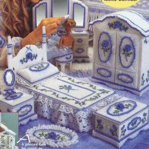 May include: Plastic canvas craft kit for a dollhouse bedroom. The kit includes a bed, dresser, vanity, and nightstand. The furniture is white with blue floral accents. The kit is designed by Diane T. Ray.