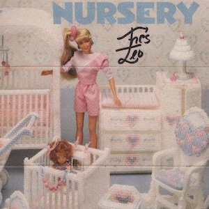May include: A vintage craft pattern for a doll nursery, featuring a Barbie doll and miniature furniture. The set includes a crib, stroller, rocking chair, and changing table, all in white with pink and blue accents. The text "Fashion Doll Nursery" is visible.