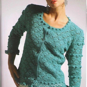 以下が含まれることがあります： ボタン留めとフリルのある裾を持つターコイズブルーのクロシェカーディガン。カーディガンは繊細なレース模様で、小さな丸い装飾が施されています。