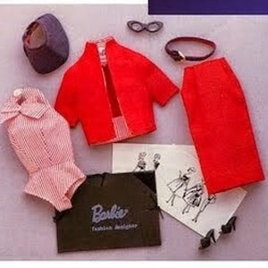 May include: A vintage Barbie doll in a red skirt suit and accessories. The doll is wearing a hat, a red jacket, and a pink and white striped blouse. The image includes a doll with a briefcase and a set of doll clothes.