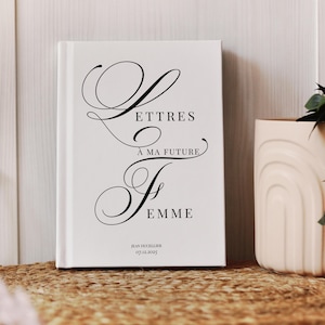 Peut inclure: Un livre blanc avec du texte noir en cursive qui dit "Lettres à ma future femme". Le livre est posé sur une surface tissée, avec un vase crème à droite. Le nom de l'auteur et la date sont en bas.