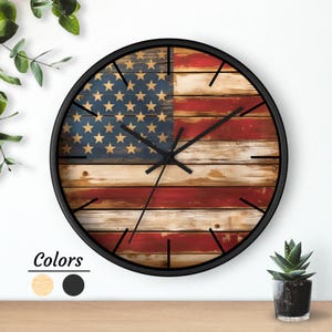 May include: A round wall clock with a black frame. The clock face features a distressed American flag design with blue stars and red and white stripes. The clock hands are black.
