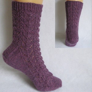 May include: Purple knitted socks with a lacy pattern. The socks are shown on a model's foot.