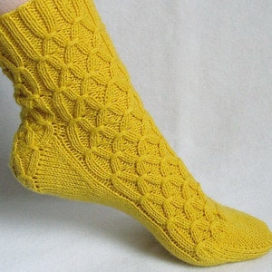 May include: A pair of yellow knitted socks with a cable knit pattern.