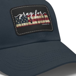 May include: A navy blue baseball cap with a patch featuring an American flag and the text "pray for AMERICA".