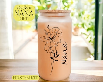 May include: A frosted glass tumbler with a bamboo lid and a straw. The tumbler has a floral design and the word "Nana" written on it. The text "Perfect Nana Gift!" is in a yellow box above the tumbler. The text "Personalized" is in a yellow box below the tumbler.