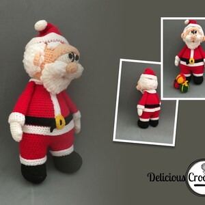 May include: A crocheted Santa Claus doll wearing a red suit with white trim, a black belt with a gold buckle, and a white beard. The doll is standing on a grey surface.