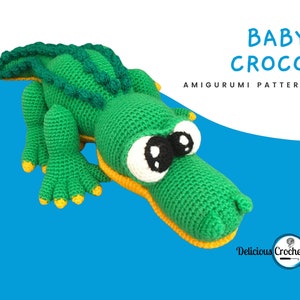 May include: Green crocheted amigurumi baby crocodile with yellow accents and large black eyes. The crochet pattern is titled "Baby Croco Amigurumi Pattern" and is from "Delicious Crochet".