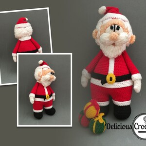 May include: A crocheted Santa Claus doll wearing a red suit with white trim, a black belt with a gold buckle, and a white beard. The doll is holding a red bag and is standing on a grey surface. The doll is surrounded by three small crocheted ornaments.