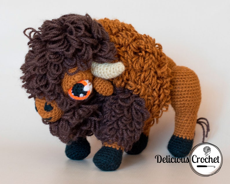 DeliciousCrochet American Bison (Buffalo). This is a crochet pattern, not the finished toy. Using DK or Sports acrylic yarn with a 2.5 mm hook, the toy stands 7.5 inches tall and 9 inches long. Instructions available in English (US) or Spanish.
