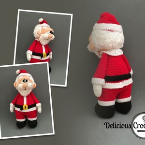 May include: A crocheted Santa Claus doll with a white beard, red suit, black belt, and white trim. The doll is standing on a grey background.