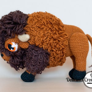 DeliciousCrochet American Bison (Buffalo). This is a crochet pattern, not the finished toy. Using DK or Sports acrylic yarn with a 2.5 mm hook, the toy stands 7.5 inches tall and 9 inches long. Instructions available in English (US) or Spanish.