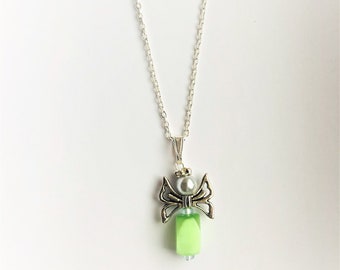 May include: A silver chain necklace with a green and silver angel pendant. The angel has wings and a pearl bead in the center.