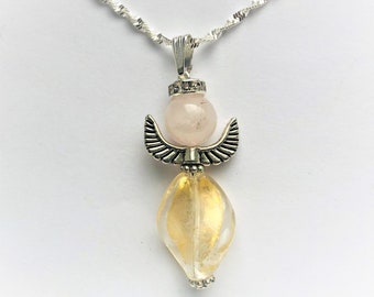 May include: A silver chain necklace with a pendant featuring a pink rose quartz bead and a gold-toned crystal bead. The pendant is shaped like an angel with wings.