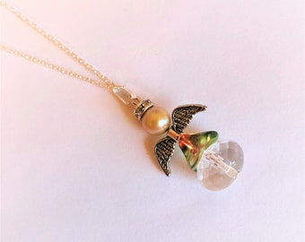 May include: A silver chain necklace with a clear crystal angel pendant. The angel has green and gold wings and a pearl bead.