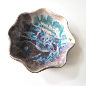 May include: A small, scalloped ceramic bowl with a blue, purple, and white marbled glaze.