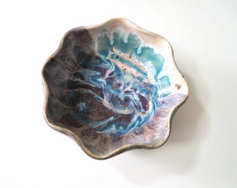 May include: A small, scalloped ceramic bowl with a blue, purple, and white marbled glaze.