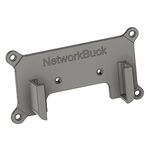 以下が含まれることがあります： 「NetworkBuck」の文字がプリントされたグレーの金属製ブラケット。ブラケットは長方形で角が丸く、取り付け用の穴がいくつかあります。2つの垂直サポートがあります。