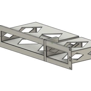 May include: A silver-colored metal rack mount component with geometric cutouts. The design features rectangular and diamond-shaped openings, and is constructed with multiple panels joined together. The component has mounting holes on the front.
