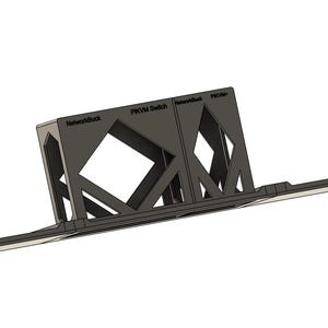 May include: A dark grey PKVM Switch, a computer hardware component, with the text "Networkbuck" and "PKVM Switch" printed on it. The component has an open, geometric design with angled supports and a flat base.