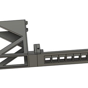 May include: A grey network patch panel with the text "NetworkBook" visible. The panel has a geometric design with multiple rectangular ports and mounting holes, designed for network infrastructure.