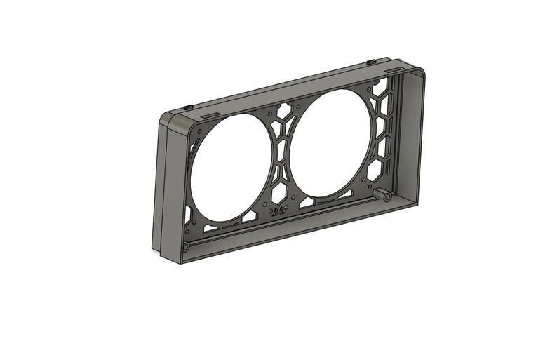 May include: A gray rectangular frame with two large circular openings and a honeycomb pattern on the sides. The frame has a series of small holes and a cylindrical projection on the side. The object is set against a white background.