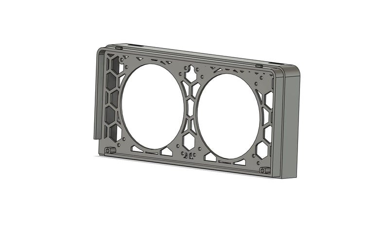 May include: A gray, rectangular metal frame with two large circular openings. The frame has a honeycomb pattern on the sides and is designed to hold two circular objects. The object is likely a component for electronics or machinery.