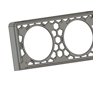 May include: A gray rectangular frame with two large circular openings. The frame has a honeycomb pattern and geometric cutouts. The design is a 3D rendering, likely for a product like a speaker grill or decorative panel.