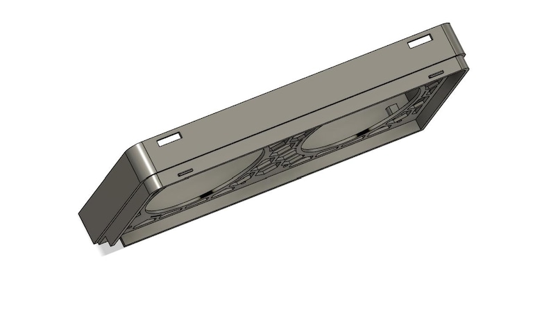 May include: A gray rectangular object with two circular indentations and a series of geometric patterns. The object has a rectangular shape with a slightly angled top and bottom. There are small rectangular cutouts on the top.